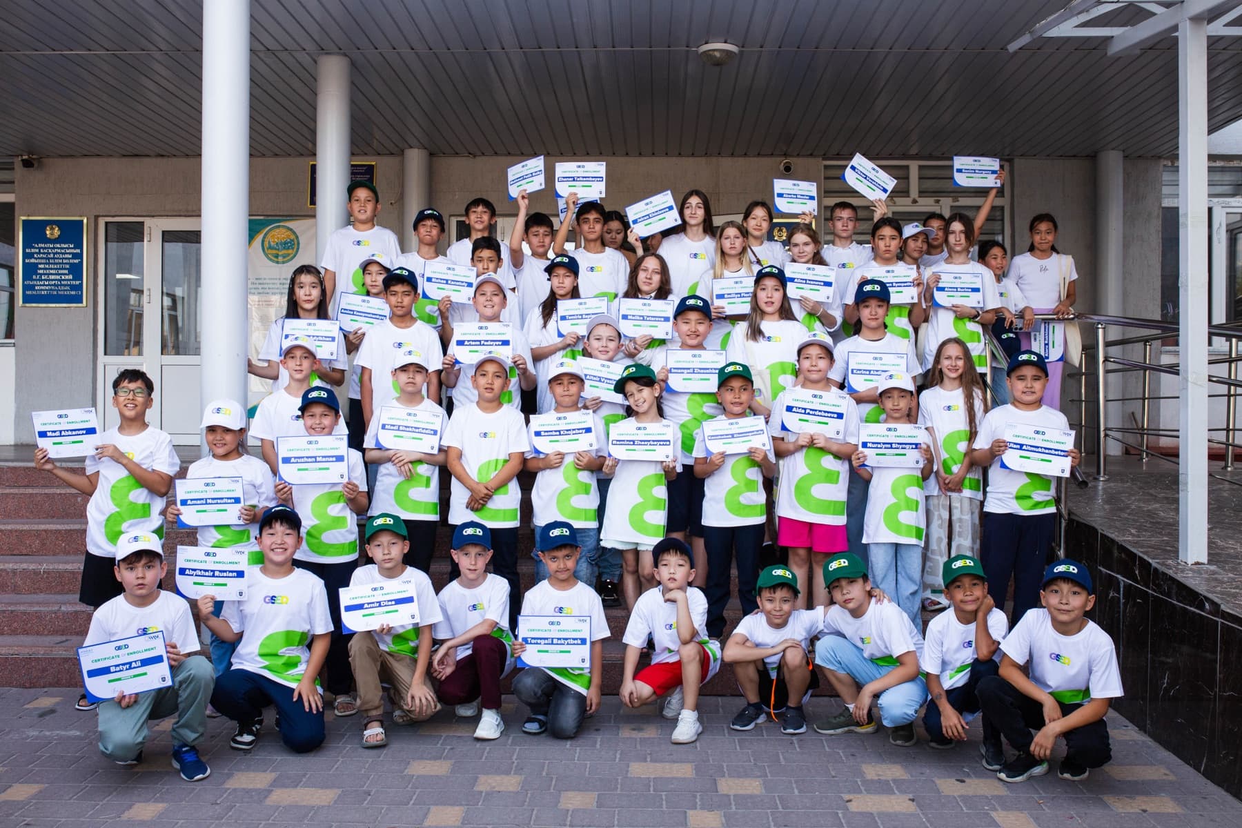 GSED students holding their certificates outside a partner school